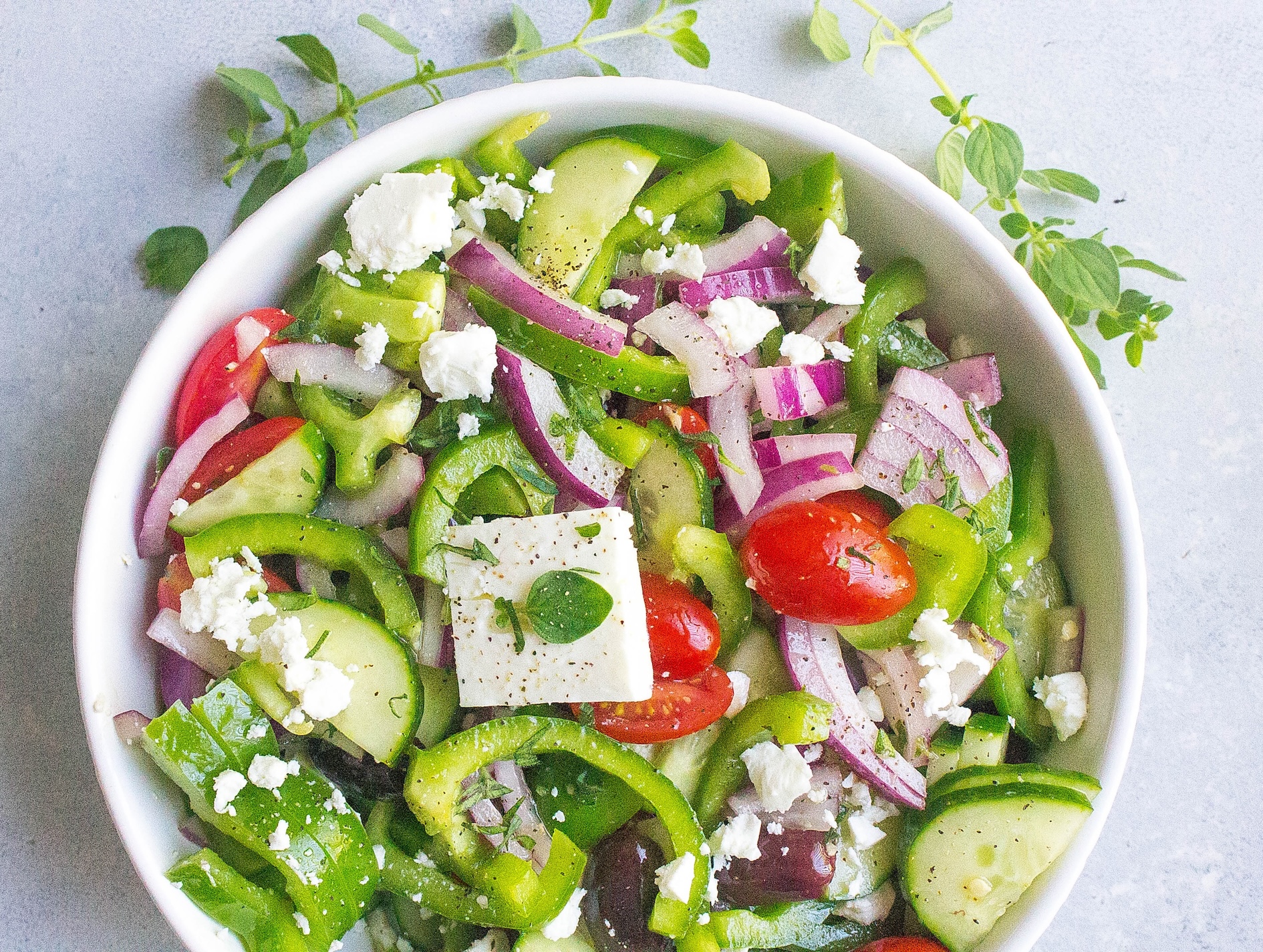 Greek salad with fresh oregano in salad bowl
